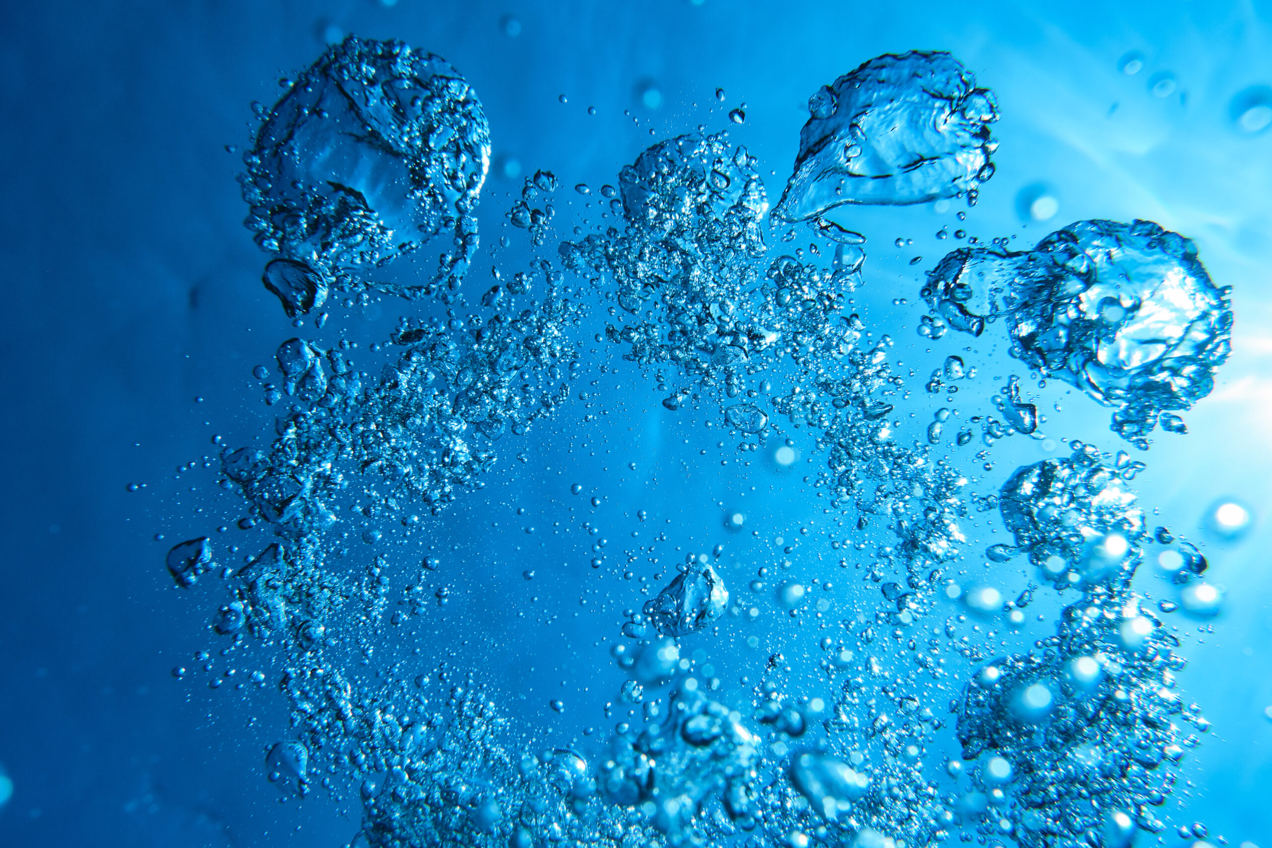 Vibrant azure water with bubbles Full frame background of abstract figures made by plenty of air bubbles in dark blue water